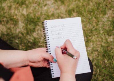 A woman writes in a Cedar and Sage journal.