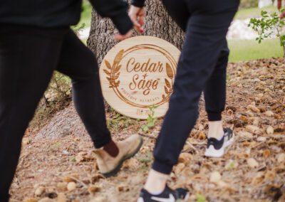 Retreats hike by a carved wood Cedar + Sage sign