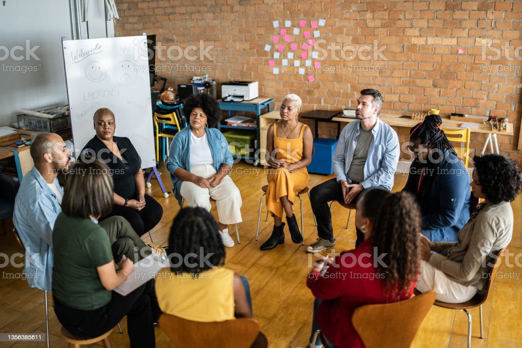 A group of women sit outside, meditating.